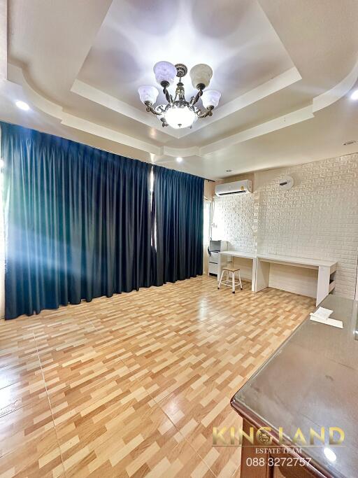 Spacious living room with wooden flooring and large windows