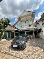 Exterior view of a residential property with a car parked in the driveway.