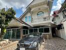 Exterior view of a residential property with a car parked in the driveway.