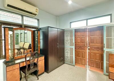 Bedroom with vanity, wardrobe, air conditioner, and large wooden doors