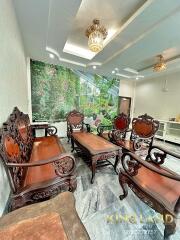 A well-furnished living room with ornate wooden furniture and a large wall mural.