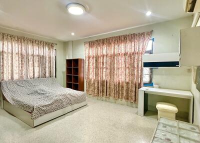 Spacious bedroom with bed, shelves, desk and air conditioning