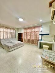 Spacious bedroom with bed, shelves, desk and air conditioning