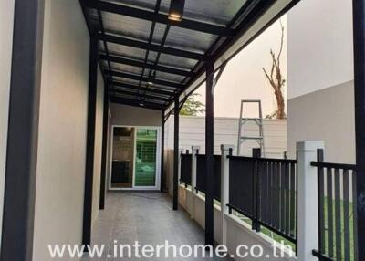 Covered outdoor corridor with fencing and tiled flooring