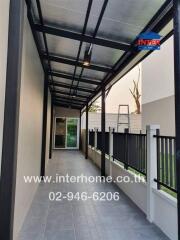 Covered outdoor corridor with fencing and tiled flooring