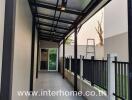 Covered outdoor corridor with fencing and tiled flooring