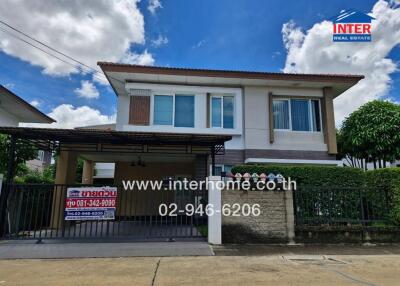 Two-story detached house with a carport and fenced yard.