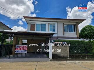 Two-story detached house with a carport and fenced yard.