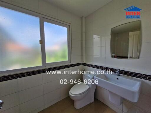 Bathroom with sink, toilet, and window