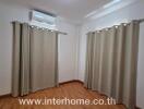 Empty bedroom with curtains and air conditioner