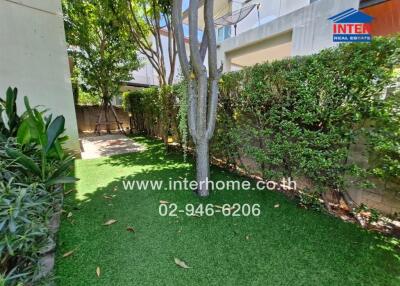 Well-maintained garden with synthetic grass and surrounding greenery