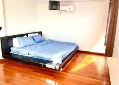 Bright bedroom with wooden floor and double bed