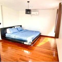 Bright bedroom with wooden floor and double bed