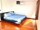 Bright bedroom with wooden floor and double bed