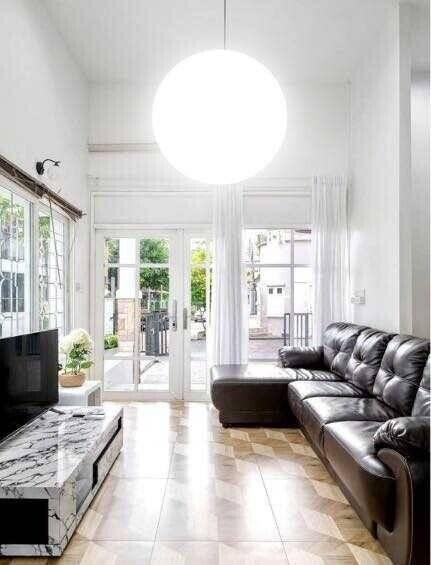 Bright and spacious living room with large windows, modern furniture, and a marble coffee table