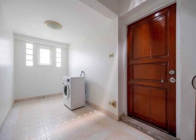 Laundry room with washing machine and wooden door