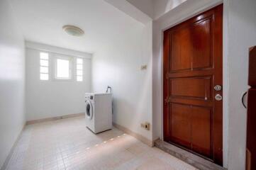 Laundry room with washing machine and wooden door