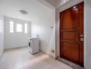 Laundry room with washing machine and wooden door