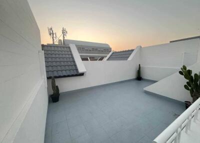 Modern balcony area at sunset with plants and urban view