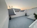 Modern balcony area at sunset with plants and urban view