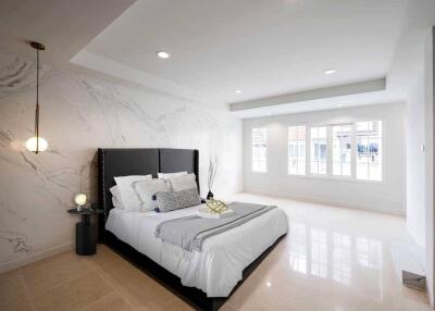 Spacious bedroom with modern decor and large windows