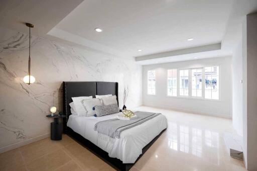 Spacious bedroom with modern decor and large windows