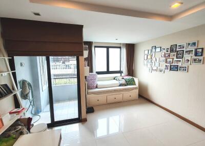 Bright bedroom with bed, large windows, and balcony