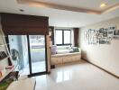 Bright bedroom with bed, large windows, and balcony