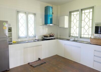 Modern kitchen with stainless steel appliances and multiple windows