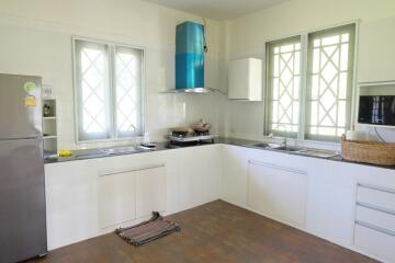 Modern kitchen with stainless steel appliances and multiple windows