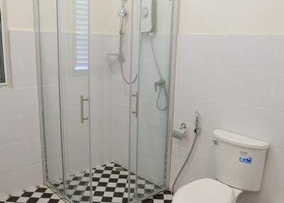 Modern bathroom with a glass shower enclosure and checkered floor tiles