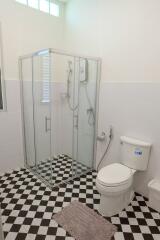 Modern bathroom with a glass shower enclosure and checkered floor tiles