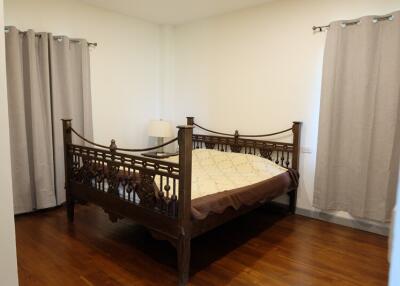 Bedroom with wooden bed and curtains