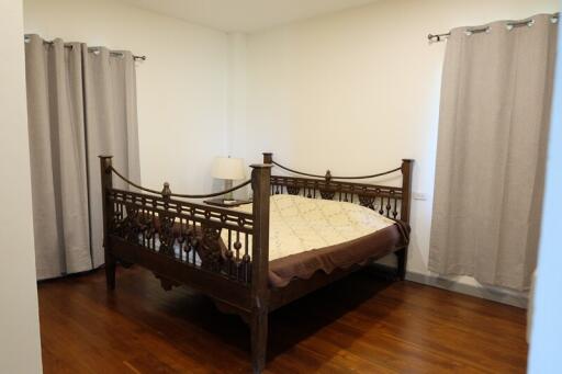 Bedroom with wooden bed and curtains