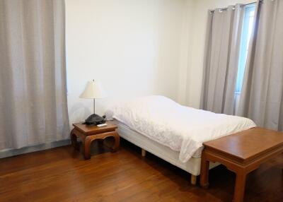 Bedroom with single bed and wooden furniture