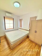 Minimalist bedroom with wooden floor, double bed, wardrobe, and air conditioning