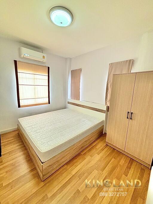 Minimalist bedroom with wooden floor, double bed, wardrobe, and air conditioning