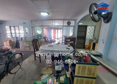 Living room with dining area featuring large windows and assorted furniture