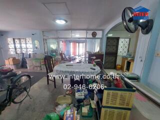 Living room with dining area featuring large windows and assorted furniture