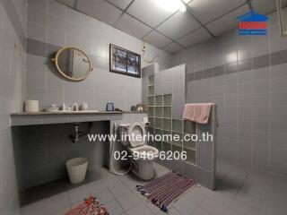 Bathroom featuring a toilet, sink, and shower area with glass partition