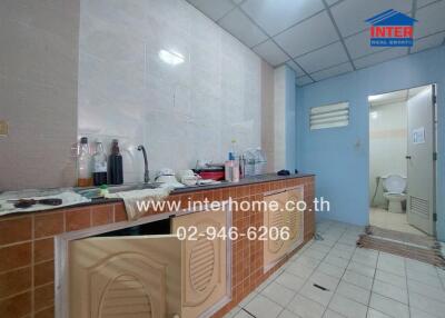 Kitchen with tiled countertops and bottles on the counter