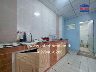 Kitchen with tiled countertops and bottles on the counter