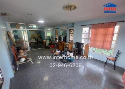 Spacious living room with large windows and various furnishings