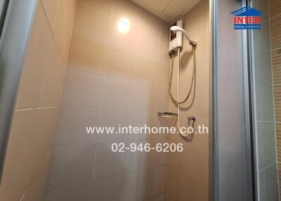 Shower area with modern fixtures in a tiled bathroom