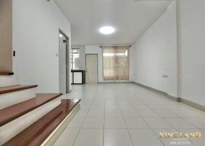 Spacious living room with stairway and large windows