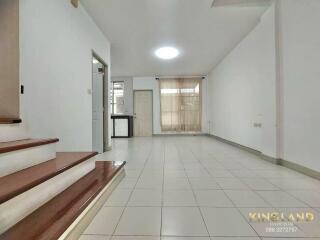 Spacious living room with stairway and large windows