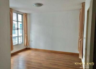 Empty bedroom with wooden floors and large window