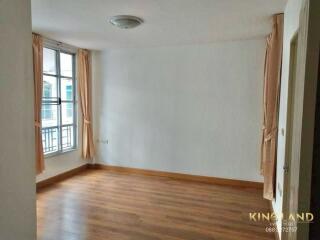 Empty bedroom with wooden floors and large window