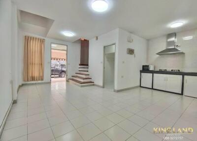 Modern kitchen and living space with tiled floor and stainless-steel appliances