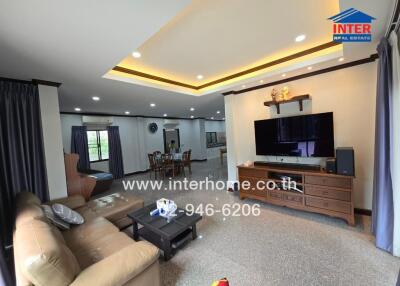 Spacious living area with modern furnishings and a large TV